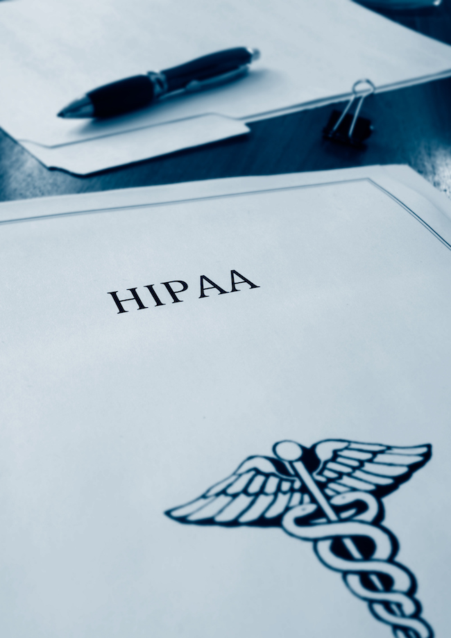 Folder with word "HIPAA" & a caduceus on it. Pen in background.