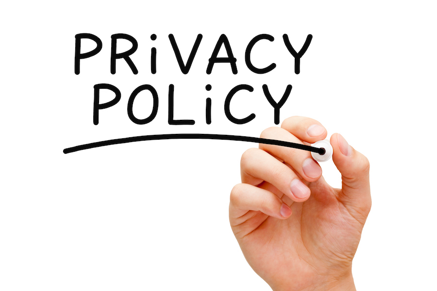 A photo of a hand writing the words "Privacy Policy."