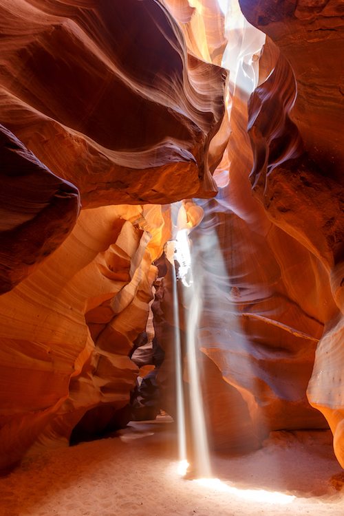 Light shining into a cave colored in russet red earthtones